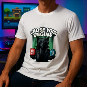 May include: White t-shirt with a cartoon black cat wearing sunglasses and a black coat, holding two game engine logos. The text "CHOSE YOUR ENGINE" is above the cat. The background is a gaming setup.