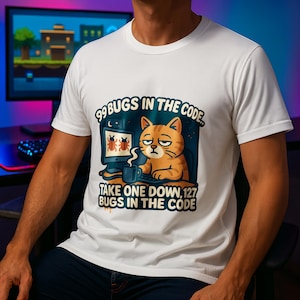 Puede incluir: Camiseta blanca con un diseño gráfico de un gato naranja cansado sentado frente a una computadora. El texto dice: "99 BUGS IN THE CODE... TAKE ONE DOWN, 127 BUGS IN THE CODE." El gato sostiene una taza.