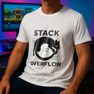 Op de afbeelding: Wit t-shirt met de tekst "STACK OVERFLOW" en een zwarte kattenafbeelding. De kat is in een cirkel gevormd met de woorden "while (true)" eromheen. Het shirt is gemaakt van een zacht materiaal.