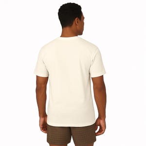 A man wearing a white t-shirt and brown shorts is facing away from the camera.