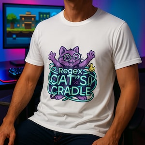 Op de afbeelding: Wit t-shirt met een paarse kattenafbeelding met een bril en de tekst "Regex CAT'S CRADLE" in teal en paars. Een kleine gele eend staat naast de kat. Een casual kledingstuk.