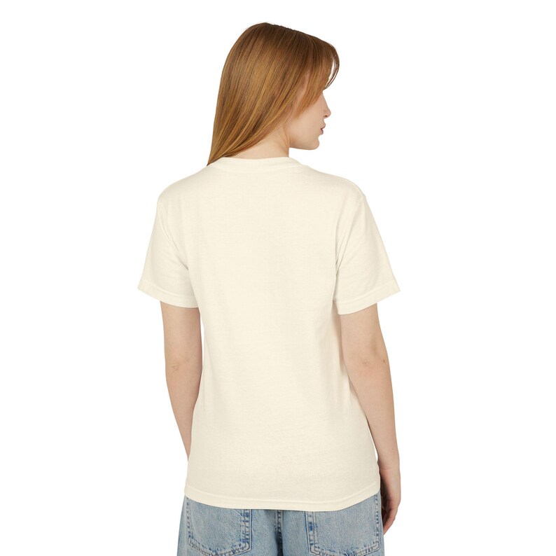 A woman with long brown hair is shown from the back, wearing a white t-shirt and blue jeans.
