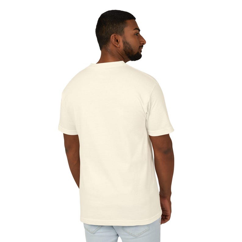 A man wearing a white t-shirt and light-colored pants is facing away from the camera, with his back turned to the viewer.