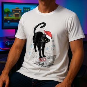 May include: White t-shirt featuring a black cat wearing a Santa hat, standing on a laptop. The cat is stepping on a red and white gift box with the word "ENTER". The laptop screen displays the text "get push origin north pole".