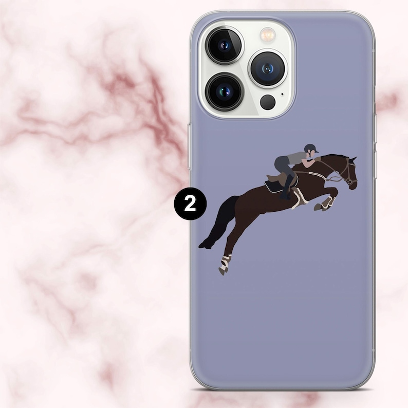 May include: A lilac phone case with a graphic of a horse and rider in mid-jump. The illustration shows a brown horse with a rider in riding gear. The case has a transparent edge and a black number 2.