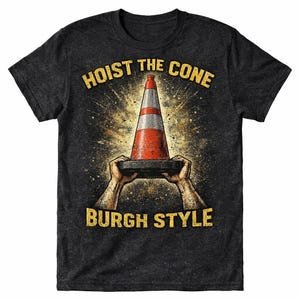 May include: Dark gray t-shirt featuring a graphic of a traffic cone held by hands, with the text "HOIST THE CONE" above and "BURGH STYLE" below. The cone is red and white, with a grunge-style background.