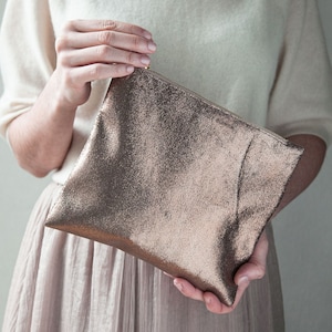 bronze purse in a model's hands