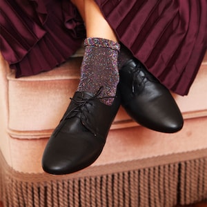 woman wearing black smooth leather oxford shoes