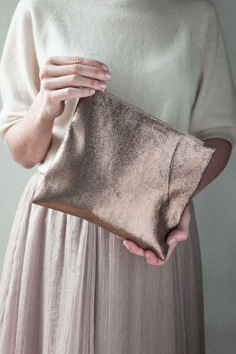 bronze purse in a model's hands