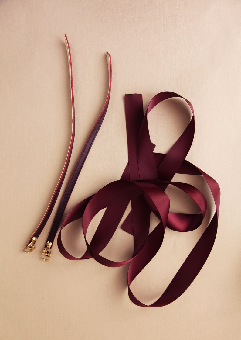 detailed photo of a pair of burgundy leather ankle straps and matching satin ribbons