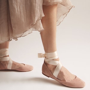 ballet flats with long satin straps worn on feet