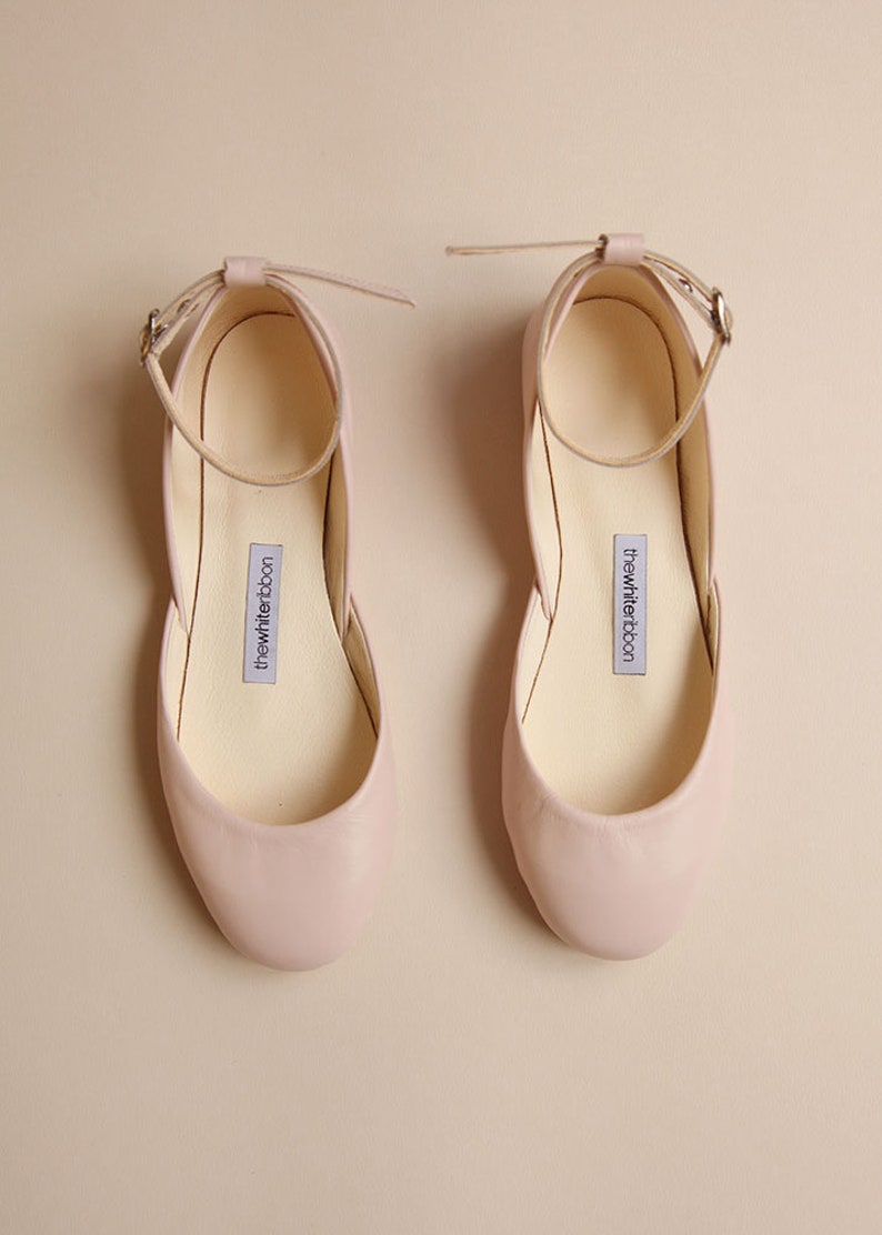 Pair of blush smooth leather ballerinas with ankle straps shown from top