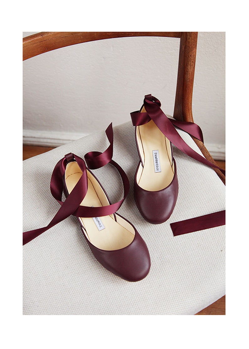 top/front view of a pair of bordeaux ballet flats with matching satin ribbons attached