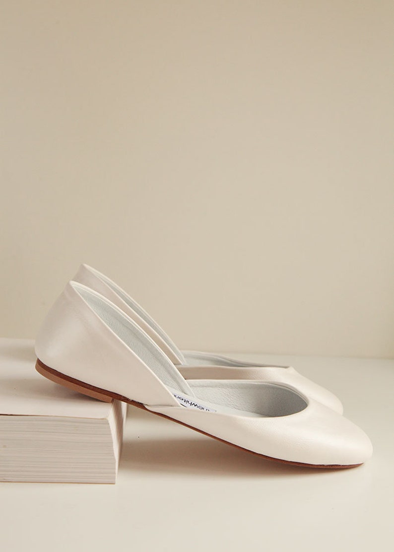 side view of a pair of shimmery smooth pearl ivory leather wedding ballet flats