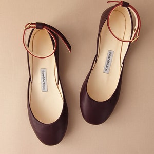 pair of bordeaux smooth leather ballerinas with leather ankle straps shown from top view