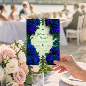 May include: A wedding invitation featuring the names "Juliana & Daniel" in elegant script. The invitation is adorned with vibrant blue roses and purple flowers, with decorative flourishes. The date and time are also displayed.