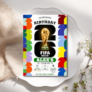 May include: A rectangular birthday invitation card featuring a large gold FIFA World Cup trophy graphic centered within the number 26. The design includes colorful geometric patterns on the sides, text reading Alex's is turning 8, and event details for Saturday, June 15, 2024, at 4:00 PM at Goal Arena.