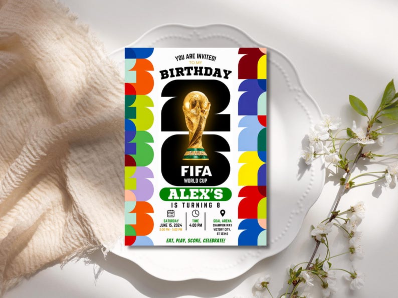 May include: A rectangular birthday invitation card featuring a large gold FIFA World Cup trophy graphic centered within the number 26. The design includes colorful geometric patterns on the sides, text reading Alex's is turning 8, and event details for Saturday, June 15, 2024, at 4:00 PM at Goal Arena.
