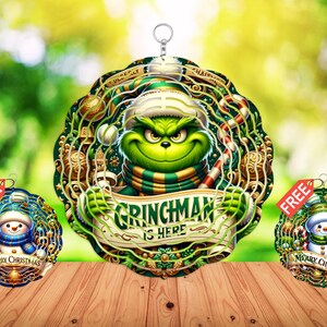 Peut inclure: Ornement de Noël avec le Grinch et le texte "Grinchman is Here". Deux petits ornements avec des bonhommes de neige et le texte "Merry Christmas" sont également inclus. Les ornements sont verts, dorés et bleus.