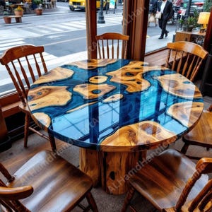 May include: A round wooden dining table with a blue epoxy resin river design. The table is surrounded by six wooden chairs. The table's base is made of wood, and the top has a glossy finish. The table is in a restaurant setting.