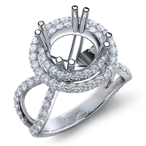 May include: A silver engagement ring setting with a double halo design. The ring features a round center setting with prongs and is surrounded by two rows of small, sparkling diamonds. The band has a split shank design, also adorned with diamonds.