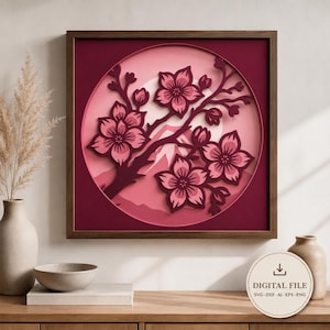 May include: A framed paper art piece featuring a cherry blossom branch with pink flowers and buds, set against a mountain scene. The artwork is in shades of pink and red, with a dark brown wooden frame. The words "DIGITAL FILE" are visible.
