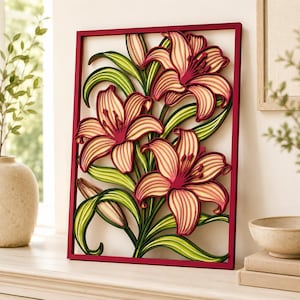 May include: A rectangular wall art piece featuring a layered, three-dimensional design of three blooming lilies and buds. The flowers are rendered in shades of cream and deep pink, accented by vibrant green leaves, all enclosed within a dark red frame.