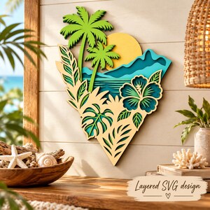 Könnte beinhalten: Ein mehrschichtiges Wandbild aus Holz mit einer tropischen Landschaft, zwei hellgrünen Palmen, einer gelben Sonne, blauen Bergen und einer großen Hibiskusblüte. Das Design enthält verschiedene Blattsilhouetten in einem hellen Beigeton.