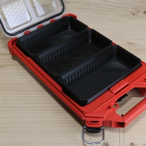 May include: A red plastic tool box with a black interior. The box has three compartments and a handle.