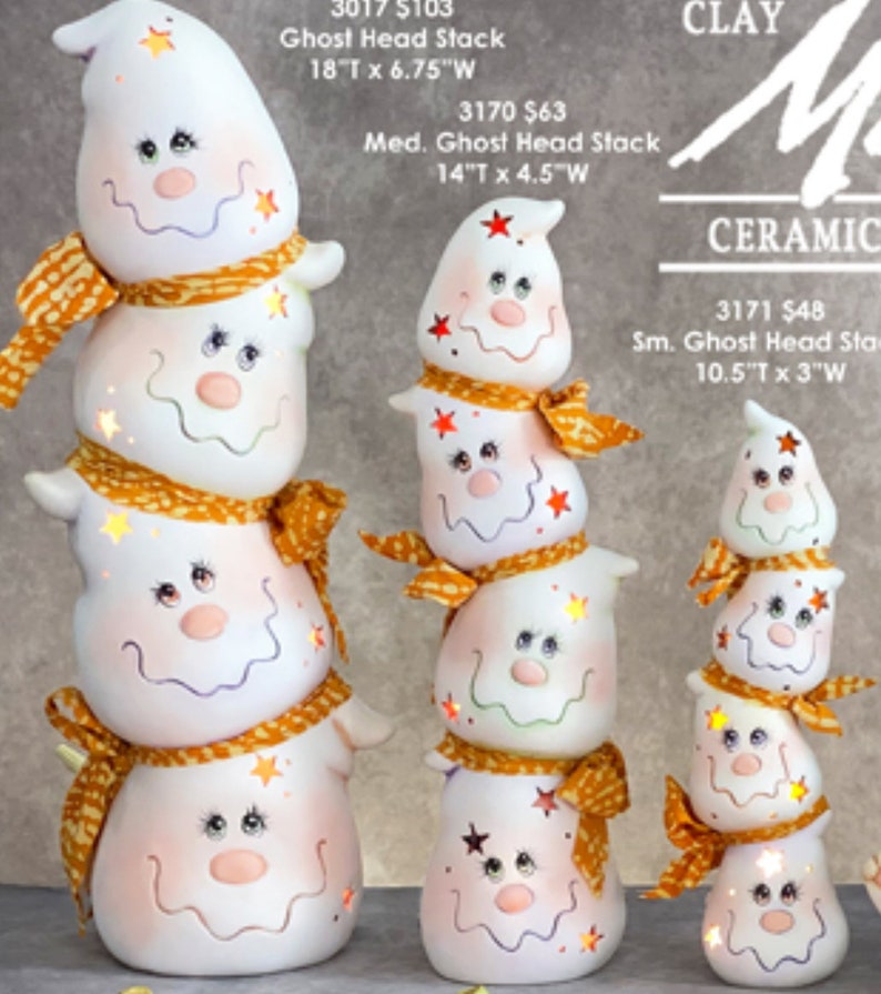 Pode incluir: Uma cole&ccedil;&atilde;o de pilhas de cabe&ccedil;as de fantasmas de cer&acirc;mica em v&aacute;rios tamanhos. Cada fantasma branco tem um rosto sorridente, detalhes de estrelas e um cachecol laranja. A pilha maior tem 45,7 cm de altura e 17,1 cm de largura.