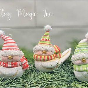 May include: Three white bird ornaments with festive hats and scarves. Each bird has a unique hat and scarf design, including red and white stripes, green and yellow stripes, and green stripes. The ornaments are decorated with glitter and a white pom-pom.