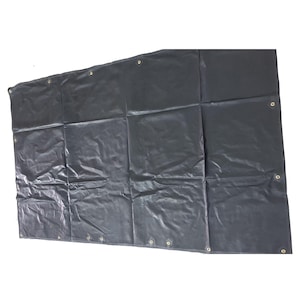 Puede incluir: Una lona negra rectangular grande con múltiples ojales de latón a lo largo de los bordes. La lona está doblada y tiene pliegues visibles. El material parece impermeable y duradero, adecuado para uso en exteriores.