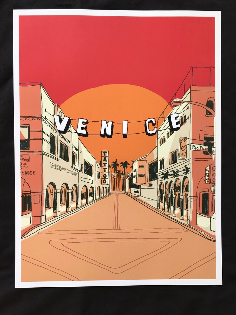 Peut inclure: Une illustration color&eacute;e d'une sc&egrave;ne de rue &agrave; Venice, en Californie. La rue est bord&eacute;e de b&acirc;timents, et une enseigne portant l'inscription &laquo; VENICE &raquo; est suspendue au-dessus de la rue. Le ciel est d'un orange et d'un rouge vifs, et des palmiers se trouvent en arri&egrave;re-plan.