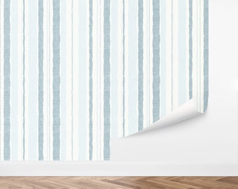 May include: Blue and white striped wallpaper with a textured, brushstroke effect. The wallpaper is shown on a white wall with a wood floor.