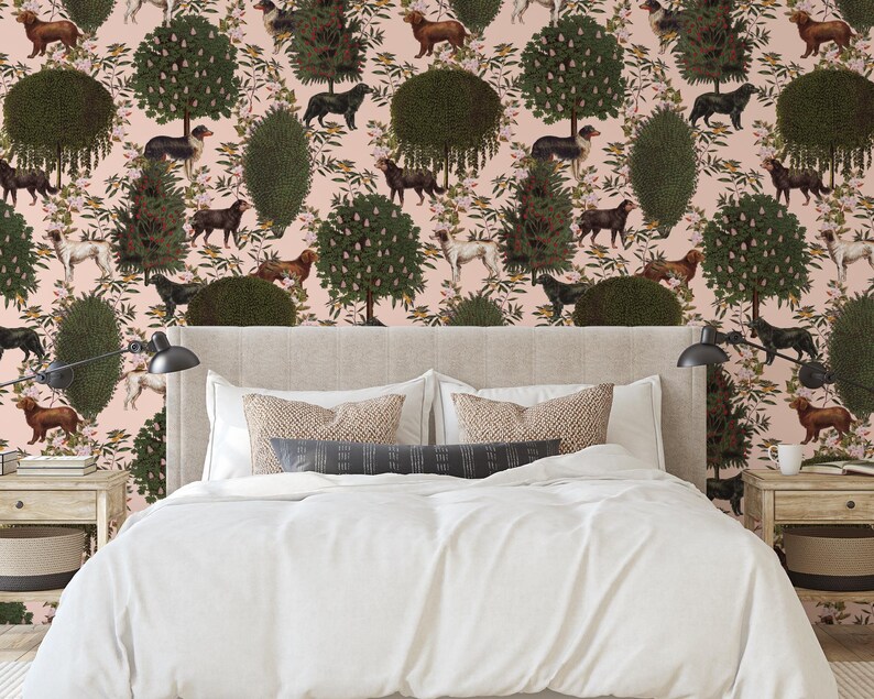 May include: A bedroom with a pink wallpaper featuring a repeating pattern of stylized trees, flowers, and dogs. The wallpaper is behind a white bed with a beige headboard and white bedding.