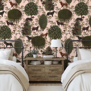 May include: Two twin beds with white linens and beige blankets in a room with pink walls and wallpaper featuring a repeating pattern of green trees, brown dogs, and white flowers.