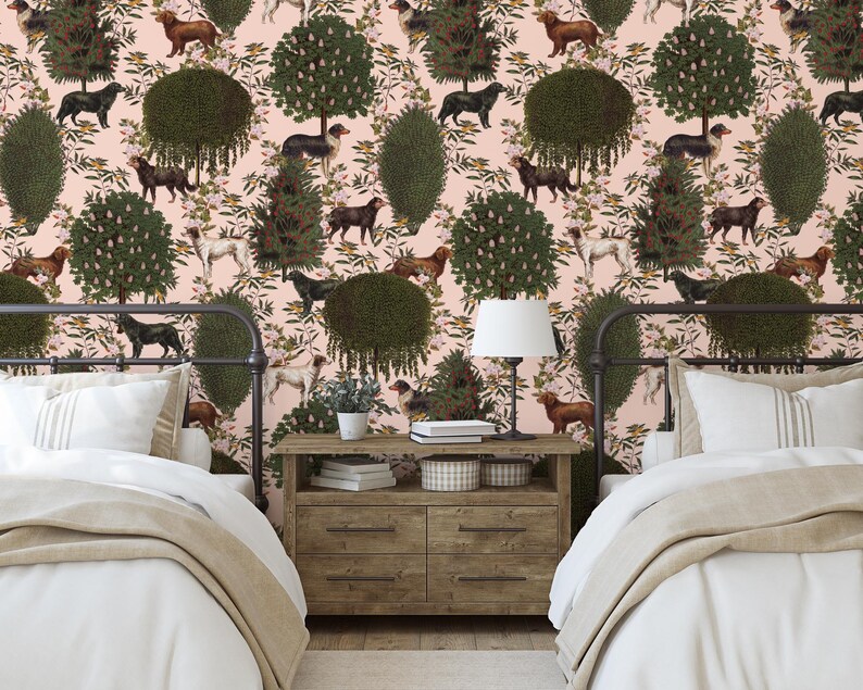 May include: Two twin beds with white linens and beige blankets in a room with pink walls and wallpaper featuring a repeating pattern of green trees, brown dogs, and white flowers.