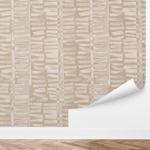 May include: Beige and off-white wallpaper with a vertical, stacked stone design. The wallpaper is partially unrolled, revealing a white backing. The pattern is a repeating series of rectangular shapes, creating a textured effect.