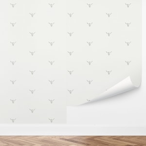 May include: White wallpaper with a repeating pattern of a black and white bull skull with horns.