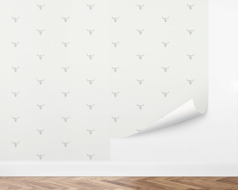 May include: White wallpaper with a repeating pattern of a black and white bull skull with horns.