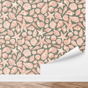 May include: A seamless pattern featuring a variety of seashells and starfish in a light pink color on a sage green background.