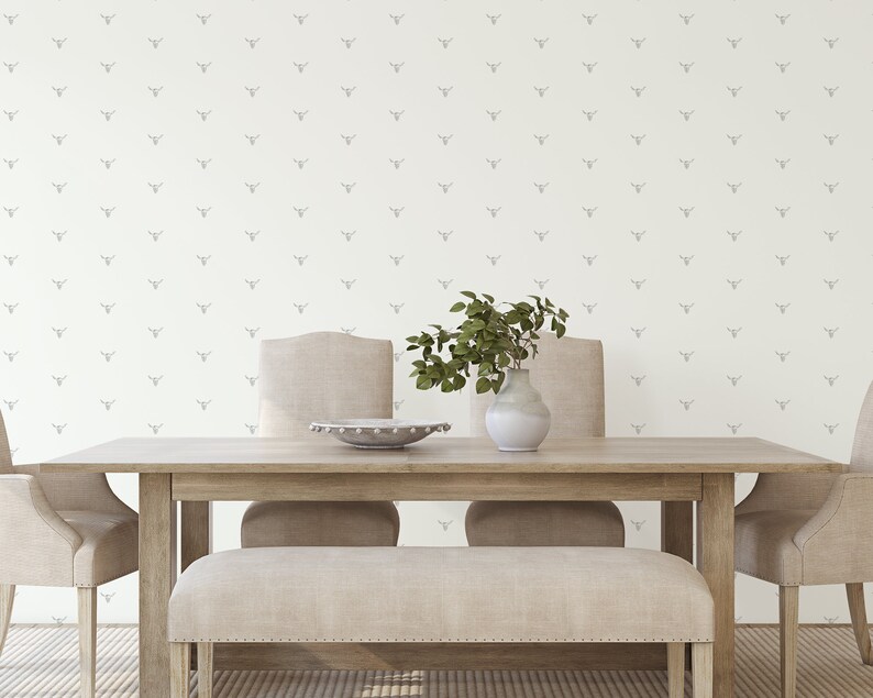 May include: A light wood dining table with four chairs and a bench. The wall behind the table has a white wallpaper with a repeating pattern of gray animal heads.