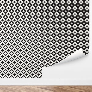 May include: Black and white geometric wallpaper with a repeating pattern of squares and crosses.