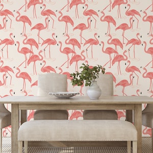 Op de afbeelding: Een witte achtergrond met een herhalend patroon van roze flamingo's. De flamingo's staan in verschillende poses, sommige staan, sommige met hun nek gebogen en sommige met hun hoofd gedraaid. De flamingo's kijken allemaal in dezelfde richting. De achtergrond is licht cr&egrave;mekleurig. De afbeelding is een behang.