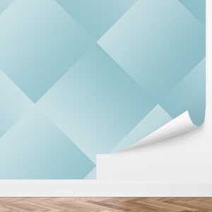 May include: A light blue wallpaper with a geometric pattern of overlapping squares. The wallpaper is shown on a white wall with a white skirting board and a wood floor.