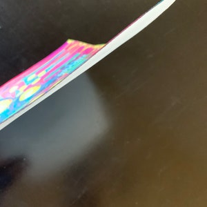 K&ouml;nnte beinhalten: Nahaufnahme des Randes eines bunten, mehrfarbigen, tie-dye, stoffbezogenen, festen Notizbuches.