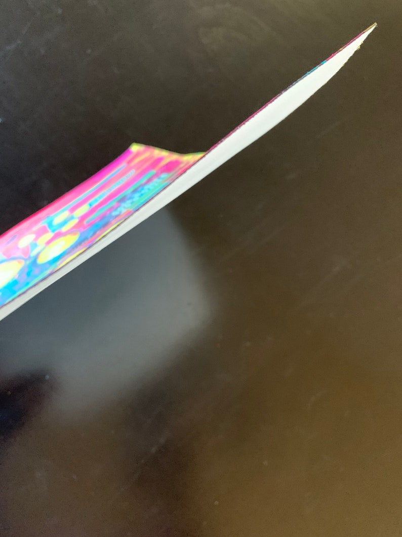 K&ouml;nnte beinhalten: Nahaufnahme des Randes eines bunten, mehrfarbigen, tie-dye, stoffbezogenen, festen Notizbuches.