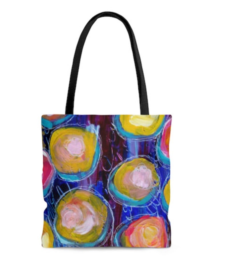 May include: A colorful tote bag with a design of overlapping circles in shades of pink, yellow, blue, and purple on a dark background.