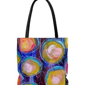 May include: A colorful tote bag with a blue background and yellow, pink, and orange circles. The circles have a white outline and are arranged in a random pattern.