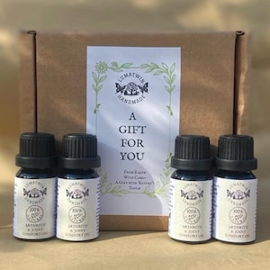 Puede incluir: Cuatro frascos pequeños de vidrio oscuro con tapas negras, cada uno con una etiqueta blanca que dice Lumatwin Handmade 100% Natural Arthritis & Joint Comfort Oil. Detrás de los frascos hay una caja de cartón marrón con una etiqueta blanca.
